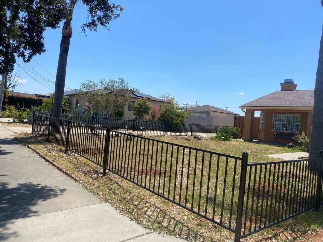 picture of a freshly installed black steel front yard fence 