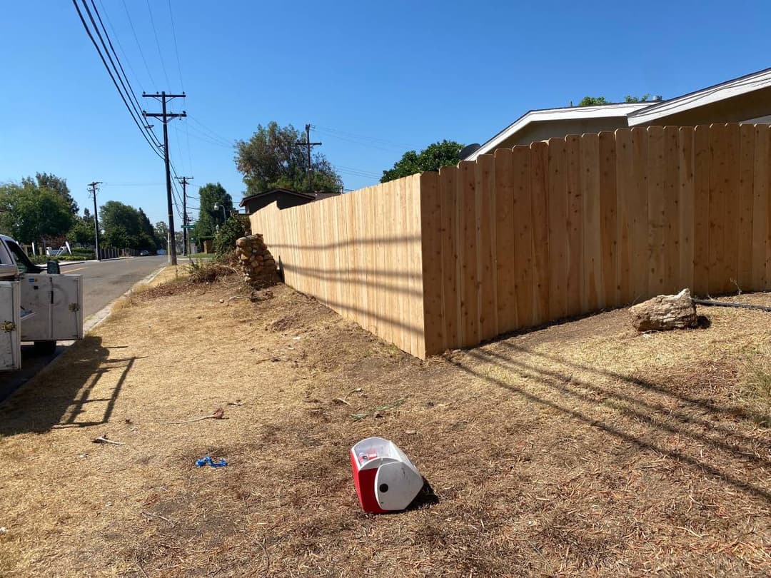 newly installed backyard tall wooden fence 